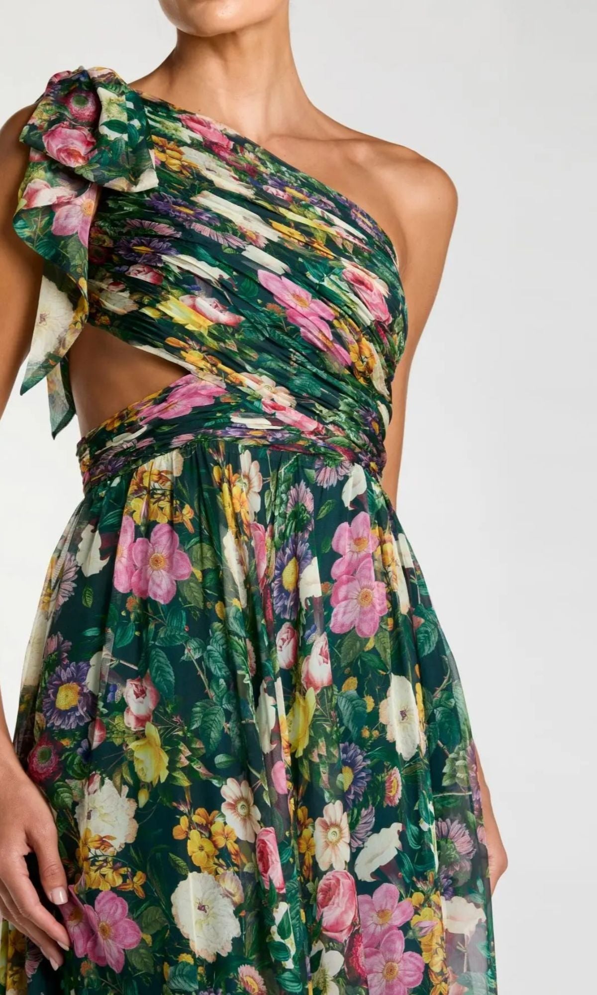 Wearing the Long Formal Dress: Mac Duggal 68553, a green one-shoulder evening gown with a floral print, side cutout, and a gathered fabric bow accenting the shoulder.